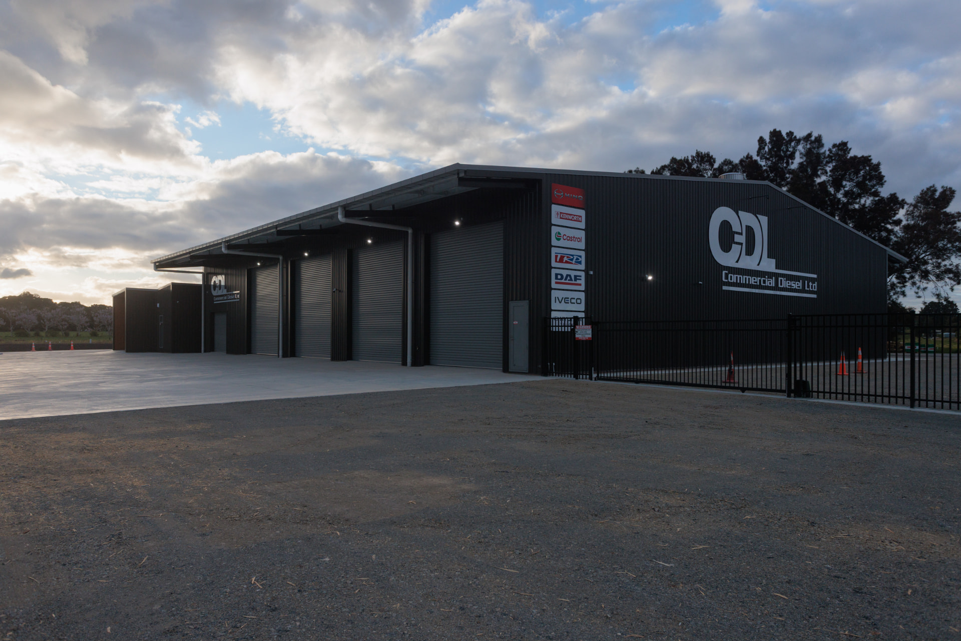 Commercial Diesel Ltd workshop exterior with roller doors at dusk
